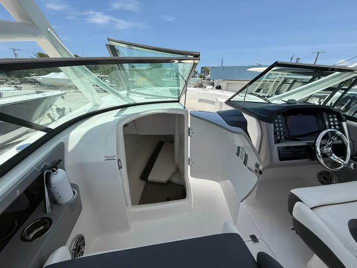 317-125 Yacht Photos Pics 2024 Robalo R317 Dual Console boat interior with modern dashboard and open cabin door.