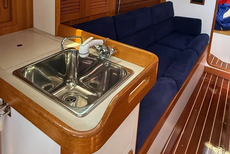 Microdarcy(ud) Yacht Photos Pics Interior of 2005 J Boats J/124, featuring a sink and blue cushioned seating.