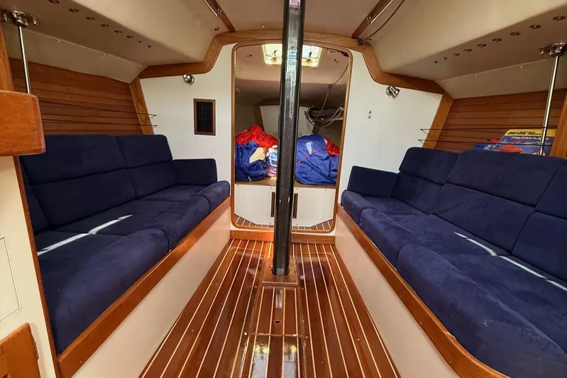 Microdarcy(ud) Yacht Photos Pics Interior of 2005 J Boats J/124 sailboat with blue seating and wooden flooring.