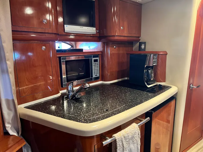 Ruby Yacht Photos Pics 2007 Four Winns 358 Vista yacht kitchen with microwave, coffee maker, and wooden cabinetry.
