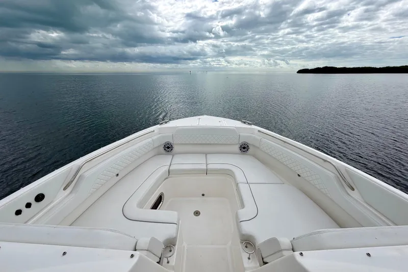  Yacht Photos Pics 2024 Pursuit DC 365 Dual Console boat on calm water under cloudy sky.