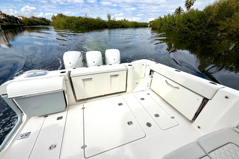  Yacht Photos Pics 2024 Pursuit DC 365 Dual Console boat on serene waterway, showcasing spacious deck.