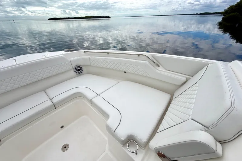  Yacht Photos Pics 2024 Pursuit DC 365 Dual Console boat with luxurious white seating on calm water.