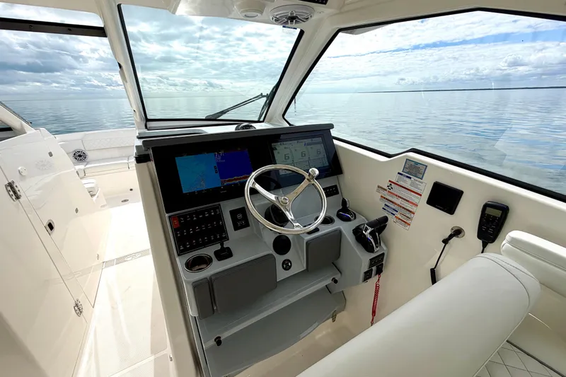  Yacht Photos Pics 2024 Pursuit DC 365 Dual Console boat interior with modern dashboard and ocean view.