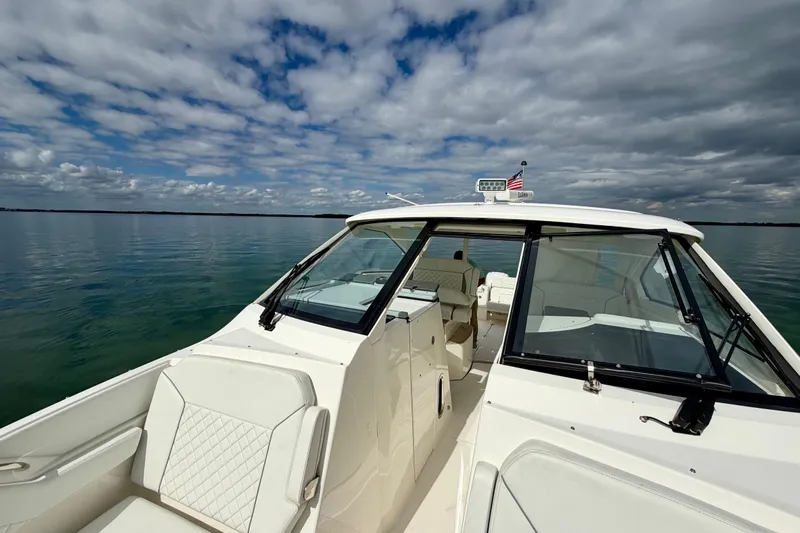  Yacht Photos Pics 2024 Pursuit DC 365 Dual Console boat on calm water under cloudy sky.