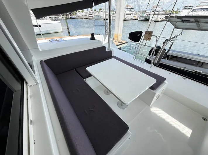 Escapist Yacht Photos Pics 2018 Lagoon 400 S2 yacht cockpit with seating and table, docked at marina.