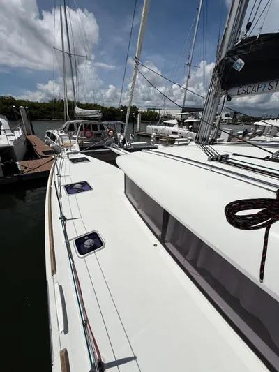 Escapist Yacht Photos Pics 2018 Lagoon 400 S2 catamaran docked at marina under a partly cloudy sky.