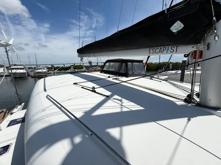 Escapist Yacht Photos Pics 2018 Lagoon 400 S2 catamaran docked at marina under clear blue sky.