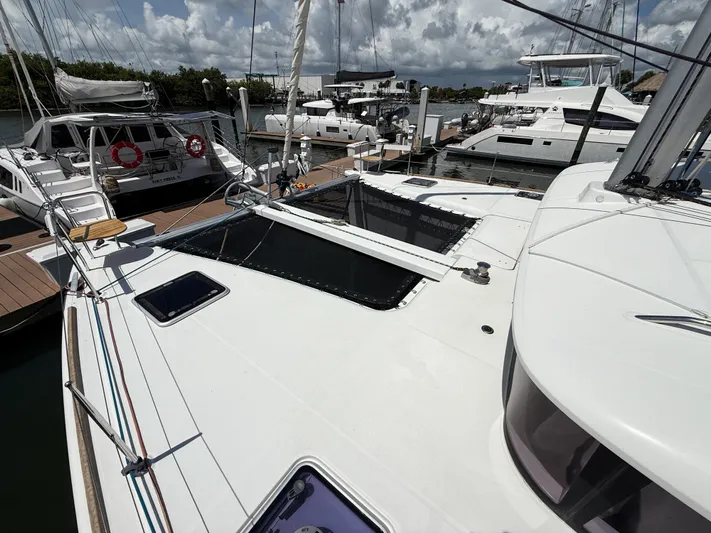 Escapist Yacht Photos Pics 2018 Lagoon 400 S2 catamaran docked at marina under cloudy sky.