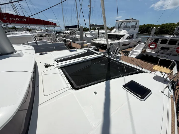 Escapist Yacht Photos Pics 2018 Lagoon 400 S2 catamaran docked at marina, surrounded by other boats under clear skies.