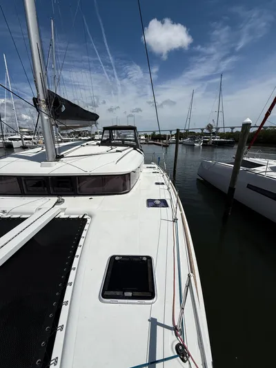 Escapist Yacht Photos Pics 2018 Lagoon 400 S2 catamaran docked in a marina under a clear blue sky.