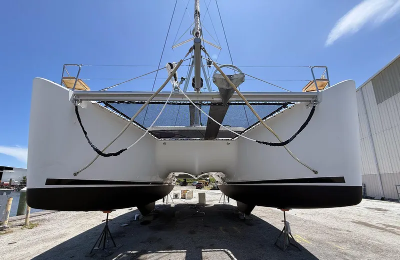 Escapist Yacht Photos Pics 2018 Lagoon 400 S2 catamaran on dry dock under clear blue sky.