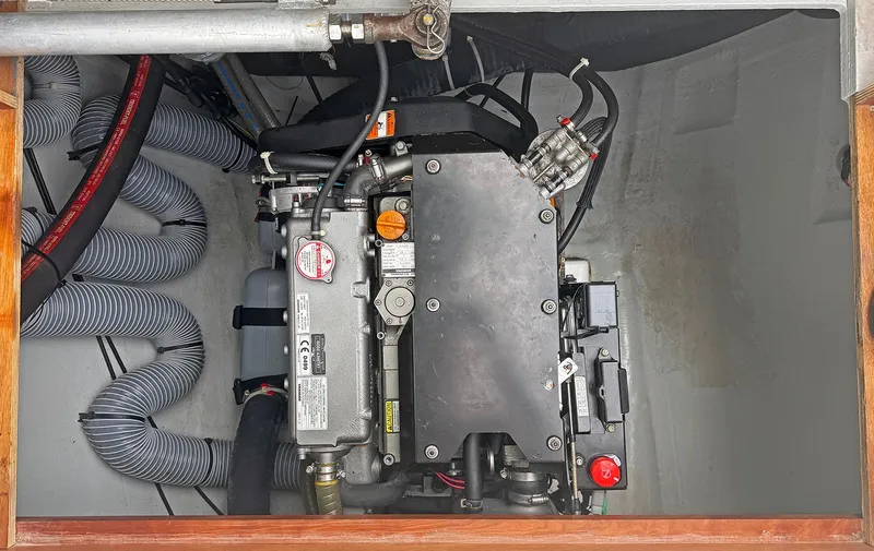 Escapist Yacht Photos Pics Engine compartment of a 2018 Lagoon 400 S2 catamaran, showcasing mechanical components and hoses.