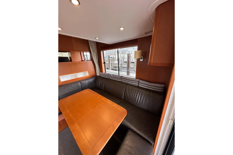 Dove Yacht Photos Pics Interior of 2015 Beneteau Swift Trawler 50 with leather seating and wooden table.