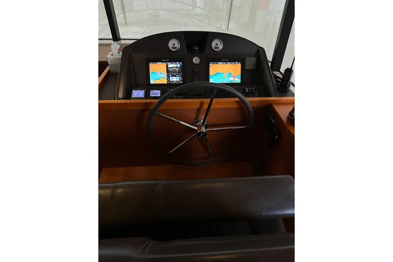 Dove Yacht Photos Pics 2015 Beneteau Swift Trawler 50 helm with navigation screens and steering wheel.
