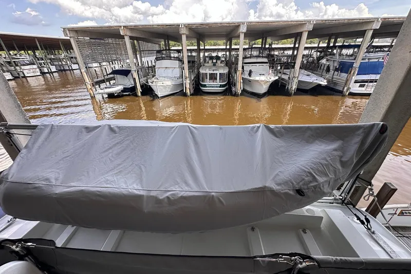 Dove Yacht Photos Pics Covered Beneteau Swift Trawler 50, 2015 model, docked among other boats in a marina.