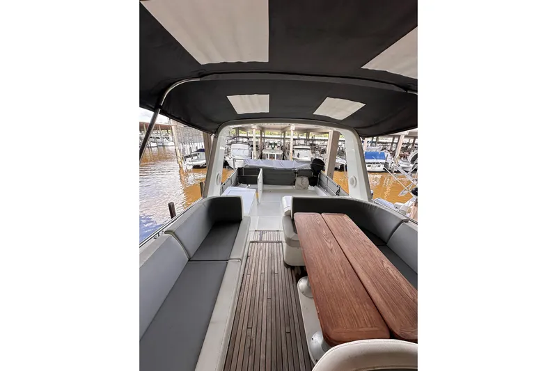 Dove Yacht Photos Pics 2015 Beneteau Swift Trawler 50 interior with seating and wooden table, docked at marina.