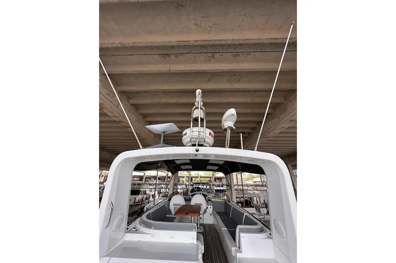 Dove Yacht Photos Pics 2015 Beneteau Swift Trawler 50, rear view under a bridge, showcasing deck and seating area.