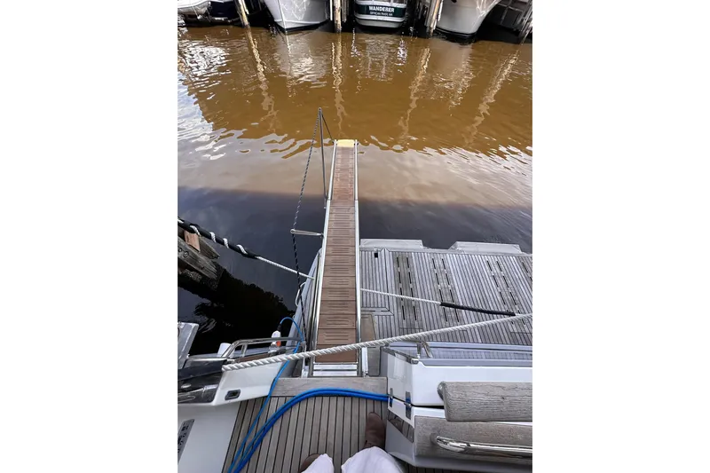 Dove Yacht Photos Pics 2015 Beneteau Swift Trawler 50 docked with wooden gangway over water.