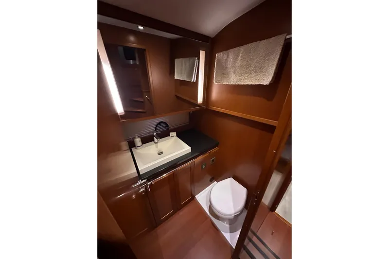 Dove Yacht Photos Pics 2015 Beneteau Swift Trawler 50 bathroom with modern sink, toilet, and wooden cabinetry.