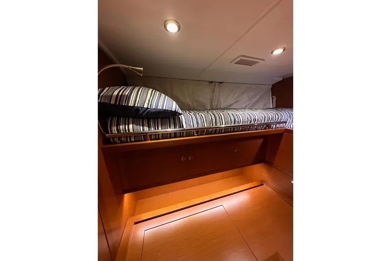 Dove Yacht Photos Pics Cozy cabin interior of 2015 Beneteau Swift Trawler 50 with striped bedding.