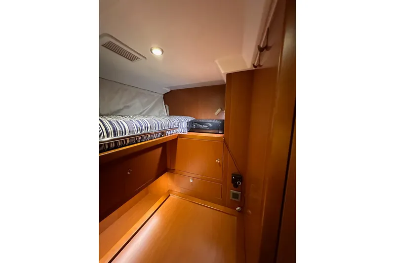 Dove Yacht Photos Pics 2015 Beneteau Swift Trawler 50 cabin interior with wooden finish and striped bedding.
