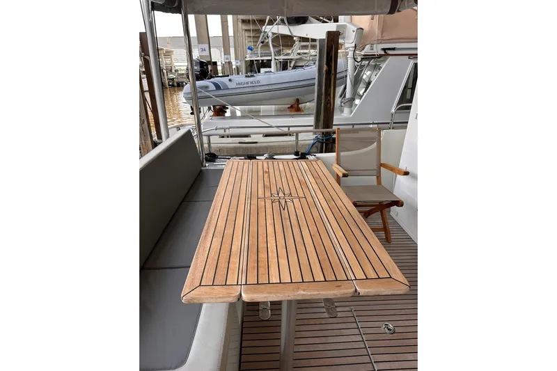 Dove Yacht Photos Pics Teak deck and table on 2015 Beneteau Swift Trawler 50 yacht, docked at marina.