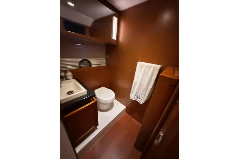 Dove Yacht Photos Pics Bathroom interior of 2015 Beneteau Swift Trawler 50 with wooden cabinetry and modern fixtures.