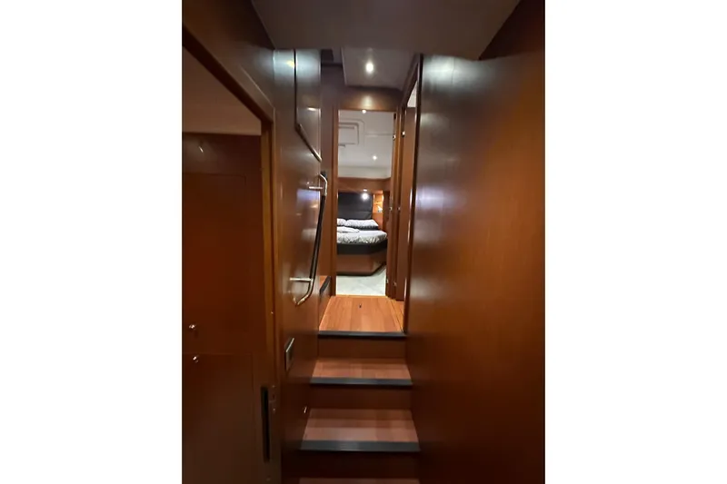 Dove Yacht Photos Pics Interior view of 2015 Beneteau Swift Trawler 50, featuring wooden stairs and cozy cabin.