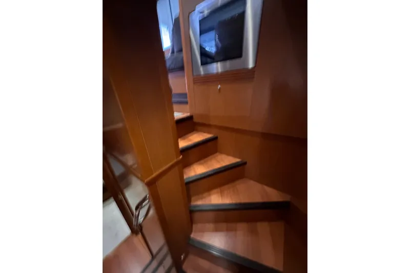 Dove Yacht Photos Pics Interior stairs of 2015 Beneteau Swift Trawler 50, featuring wooden finish and modern design.