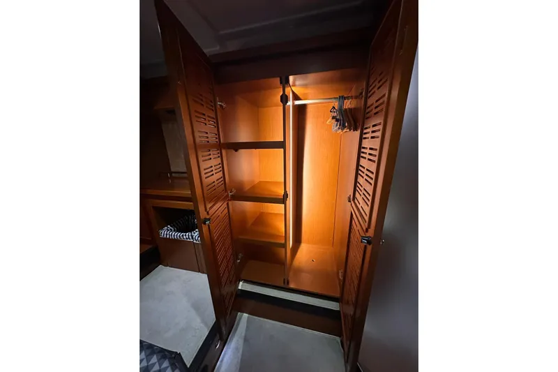Dove Yacht Photos Pics Wooden closet interior on 2015 Beneteau Swift Trawler 50, featuring shelves and hangers.