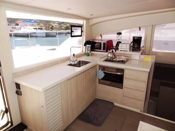 Livitup Yacht Photos Pics Modern kitchen interior of 2017 Leopard 43 Powercat yacht with appliances and large window view.