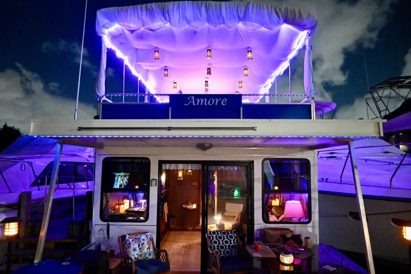 Amore Yacht Photos Pics 1996 Catamaran Cruisers Aqua Cruiser 44 with illuminated deck and cozy interior at night.