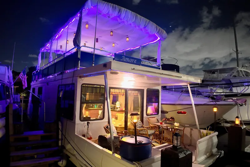 Amore Yacht Photos Pics 1996 Catamaran Cruisers Aqua Cruiser 44 with purple lights, docked at night.