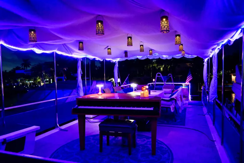 Amore Yacht Photos Pics Luxurious 1996 Catamaran Cruisers Aqua Cruiser 44 with elegant evening lighting and piano setup.