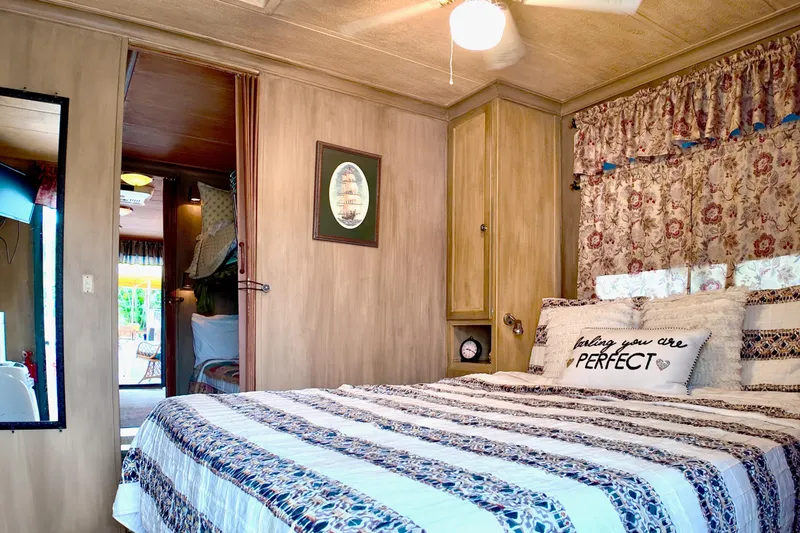 Amore Yacht Photos Pics Cozy bedroom in 1996 Catamaran Cruisers Aqua Cruiser 44 with floral decor and striped bedding.