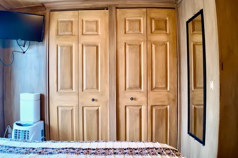 Amore Yacht Photos Pics Interior of 1996 Catamaran Cruisers Aqua Cruiser 44 with wooden closets and wall-mounted TV.