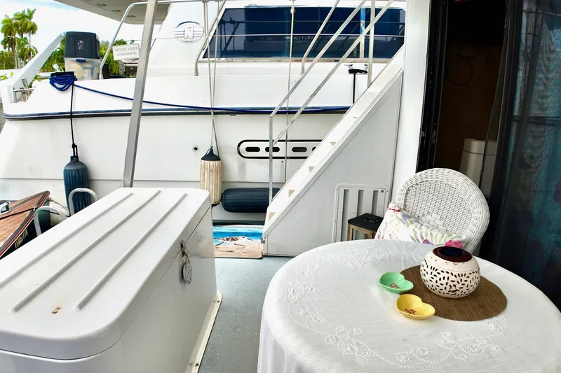 Amore Yacht Photos Pics 1996 Catamaran Cruisers Aqua Cruiser 44 deck with table, chairs, and stairs.