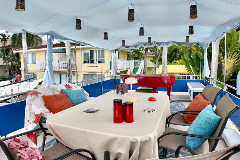 Amore Yacht Photos Pics 1996 Catamaran Cruisers Aqua Cruiser 44 deck with table, chairs, and colorful decor.