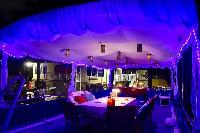 Amore Yacht Photos Pics 1996 Catamaran Cruisers Aqua Cruiser 44 with illuminated deck and canopy at night.