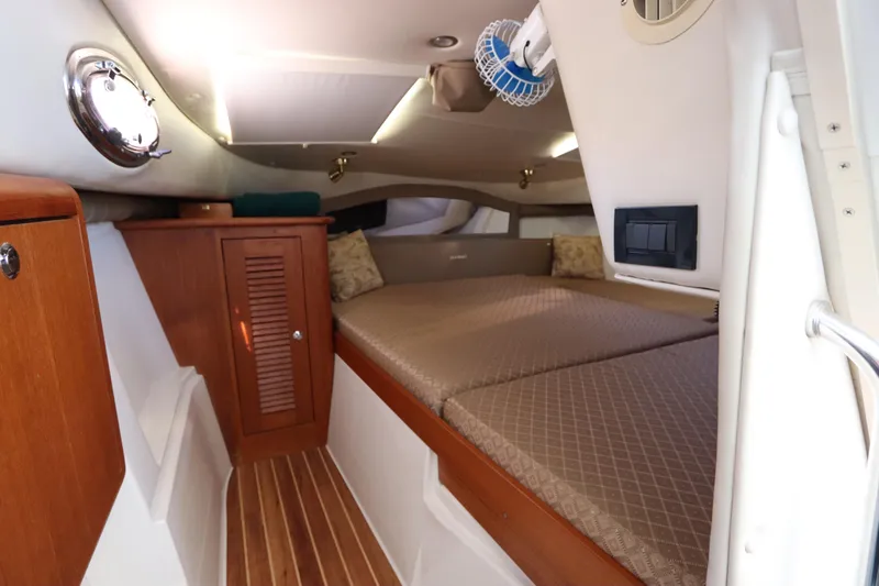  Yacht Photos Pics 2008 Glacier Bay 3080 Coastal Runner cabin interior with wood accents and cozy bedding.