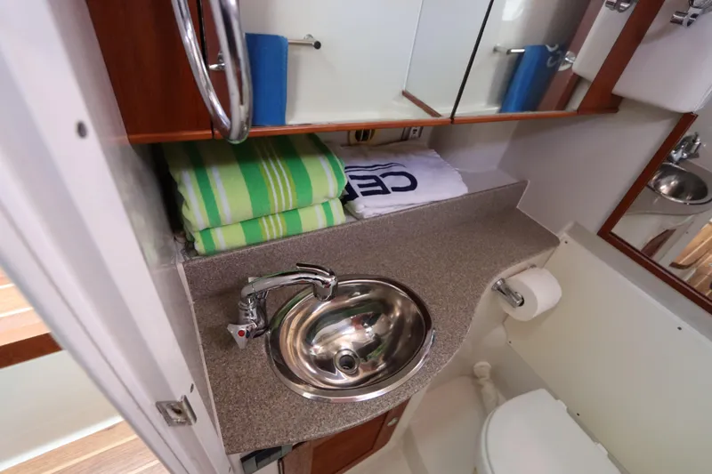  Yacht Photos Pics 2008 Glacier Bay 3080 Coastal Runner bathroom with sink, mirror, and towels.