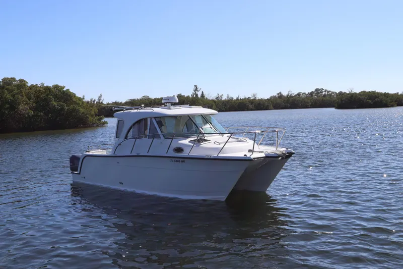  Yacht Photos Pics 2008 Glacier Bay 3080 Coastal Runner boat on calm water, surrounded by trees.