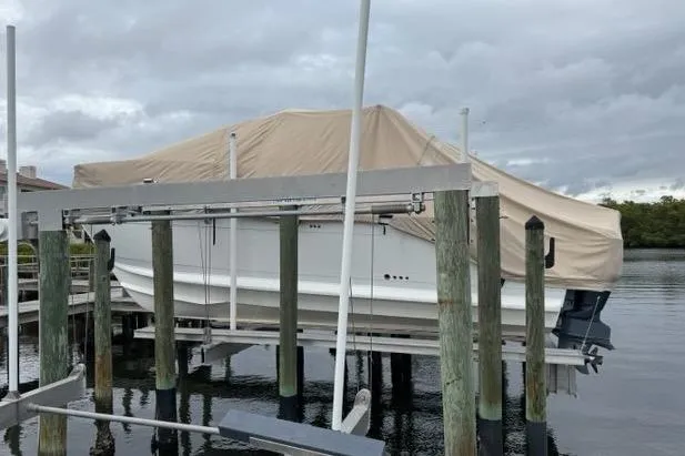  Yacht Photos Pics Covered 2008 Glacier Bay 3080 Coastal Runner on a boat lift, overcast sky.