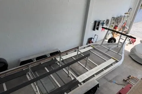  Yacht Photos Pics 2008 Glacier Bay 3080 Coastal Runner boat trailer in a garage setting.