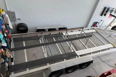  Yacht Photos Pics 2008 Glacier Bay 3080 Coastal Runner trailer in a garage, viewed from above.