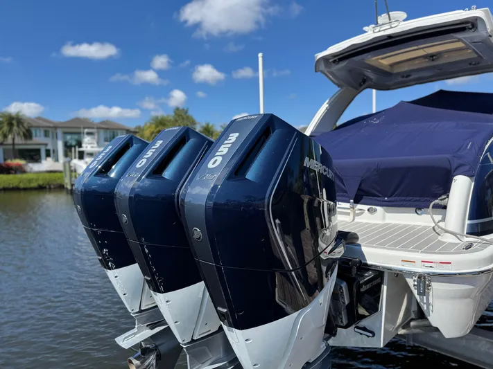 Uncorked Yacht Photos Pics 2023 Formula 350 Crossover Bowrider with triple outboard engines docked by the water.