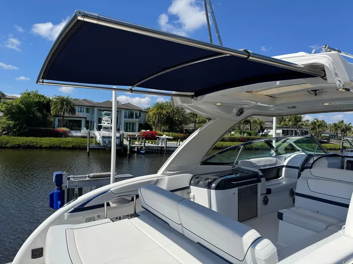 Uncorked Yacht Photos Pics 2023 Formula 350 Crossover Bowrider with canopy, docked by waterfront homes.