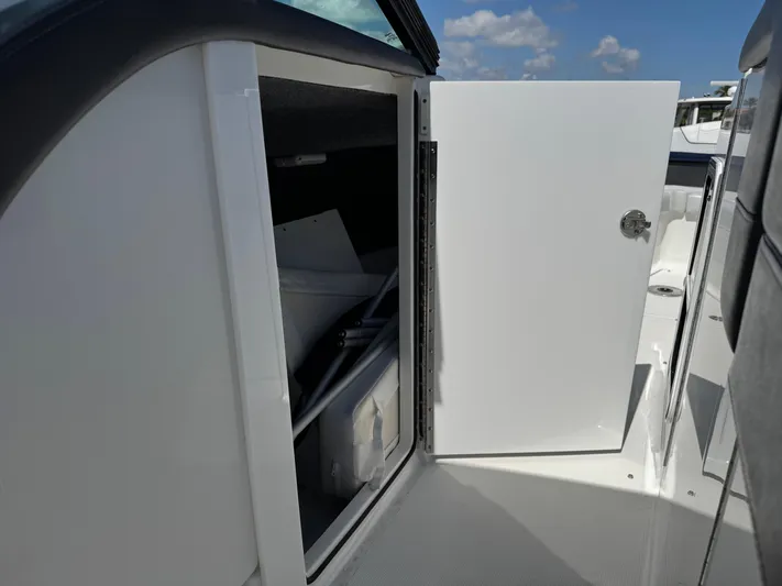 Uncorked Yacht Photos Pics 2023 Formula 350 Crossover Bowrider storage compartment with open door under clear sky.