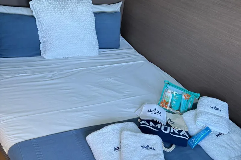 Amura Yacht Photos Pics Cozy bed with Amura-branded towels and toiletries on a Bali 5.4 Open Space yacht.